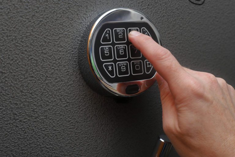Hand enters combination on a digital lock of a gun safe door